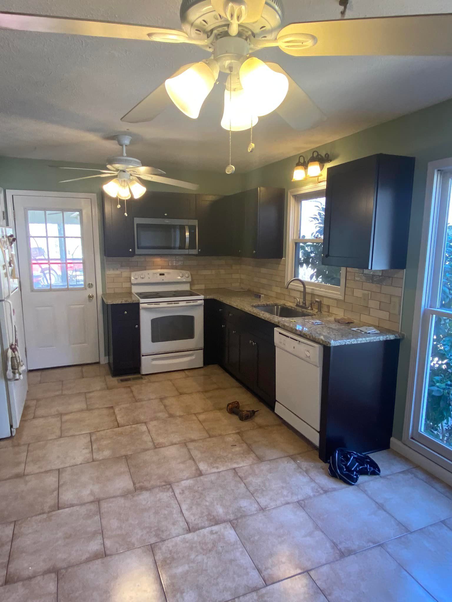 An empty kitchen with a ceiling fan and a stove.