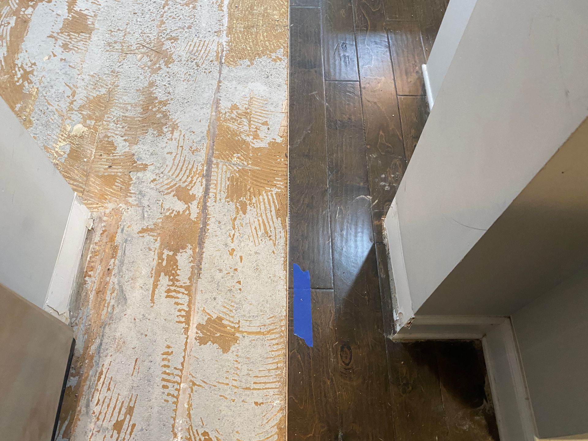 A room with a wooden floor and a concrete floor.