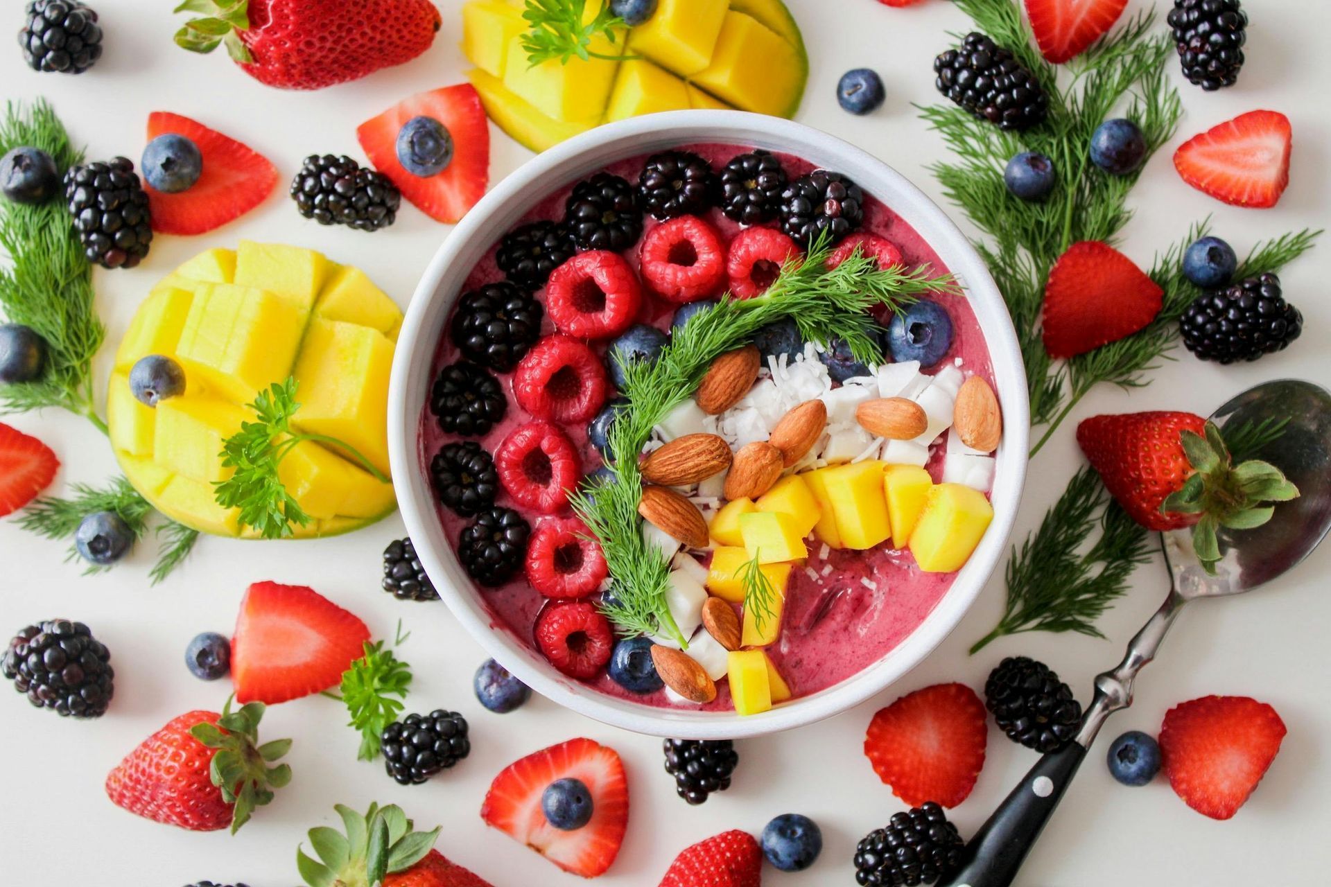Smoothiebowl met bessen, mango en amandelen.