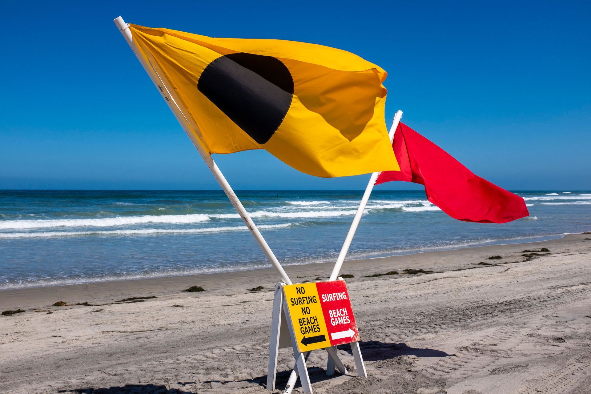 A yellow flag and a red flag on a beach