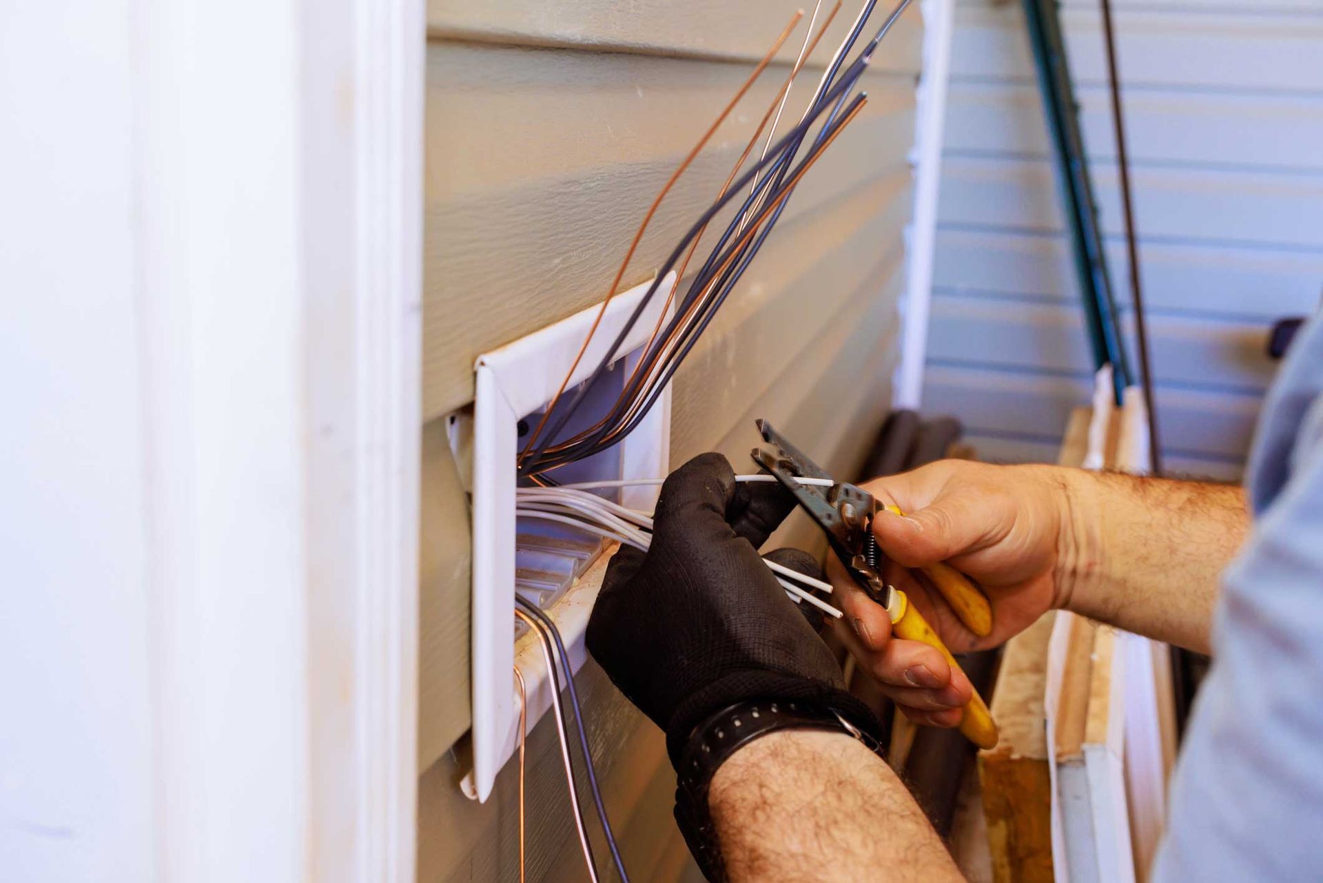 Residential electrician installing exterior wiring. Residential electrician installing exterior wiring.