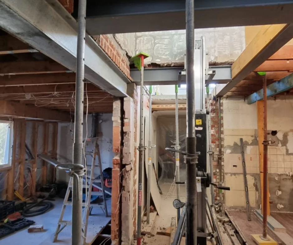 Interior construction site with exposed beams, scaffolding, and wall framing under renovation. Interior construction site with exposed beams, scaffolding, and wall framing under renovation.