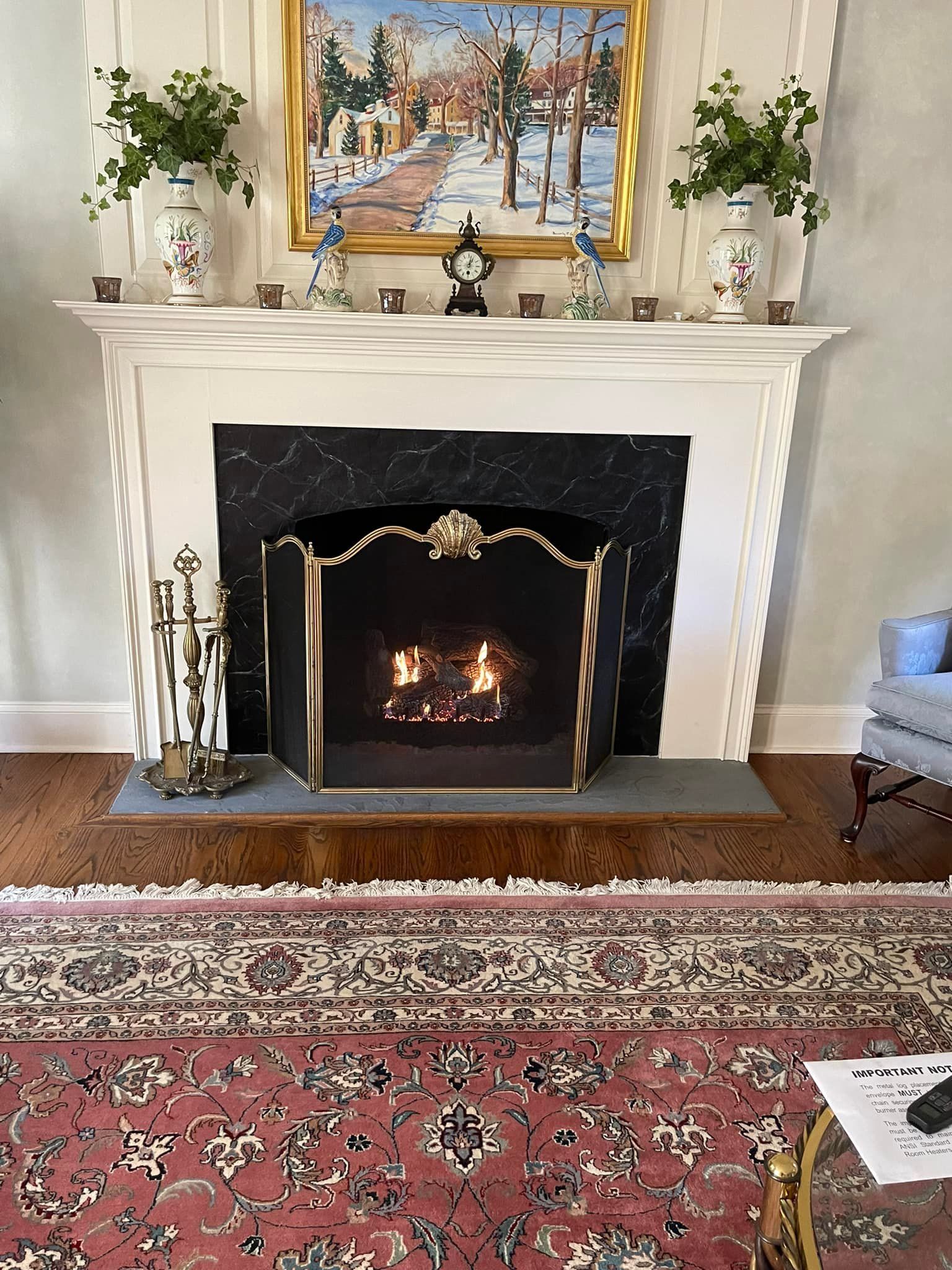 A living room with a fireplace and a rug.