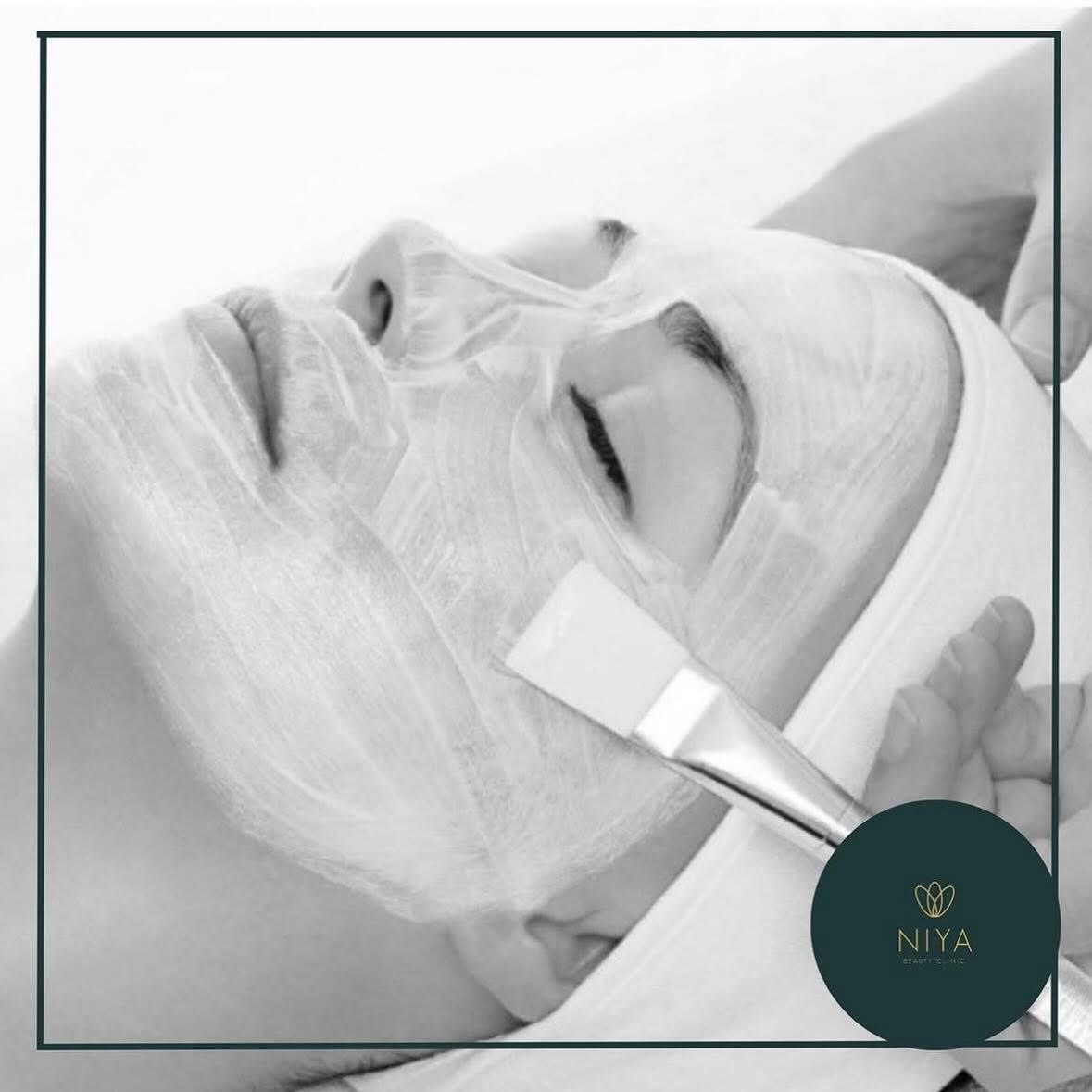 Person receiving facial treatment; cream applied with a brush.