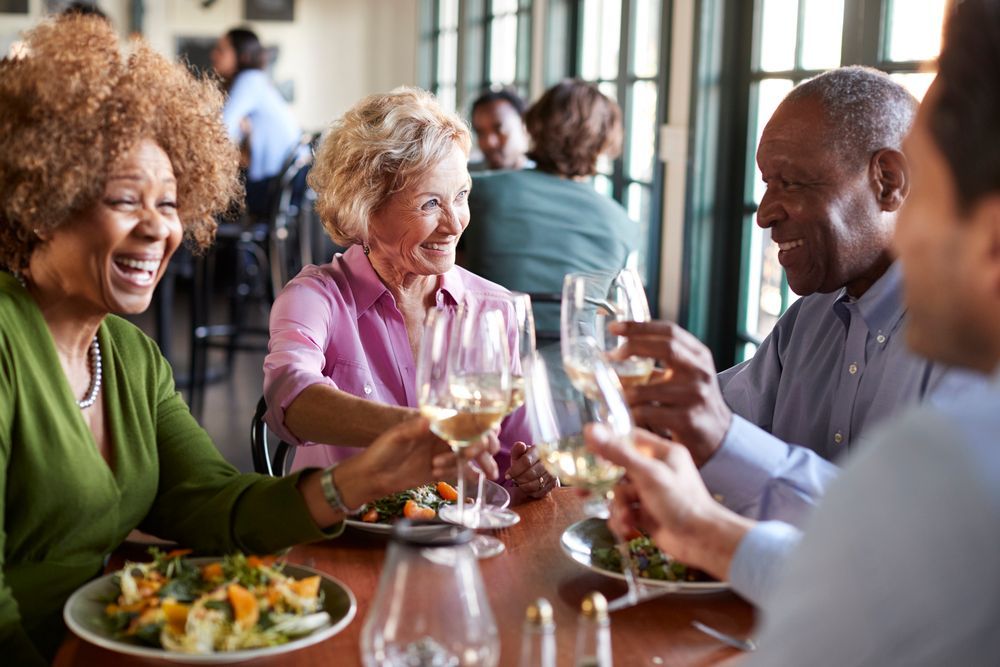 two couples enjoying dinner and wine