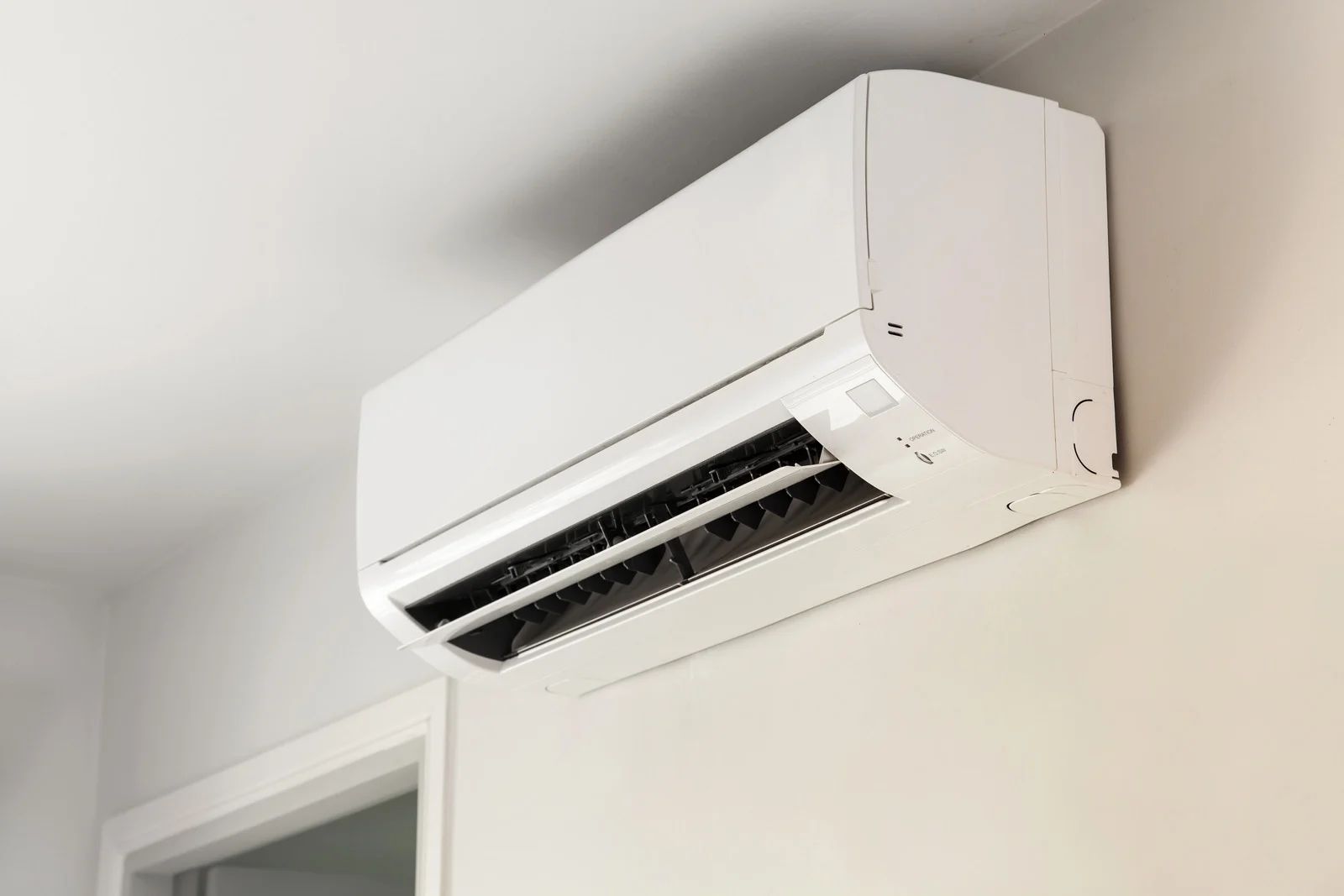 White air conditioning unit mounted on a beige wall.