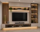 Pared multimedia moderna en la sala de estar con televisor, estantes de madera cálida.