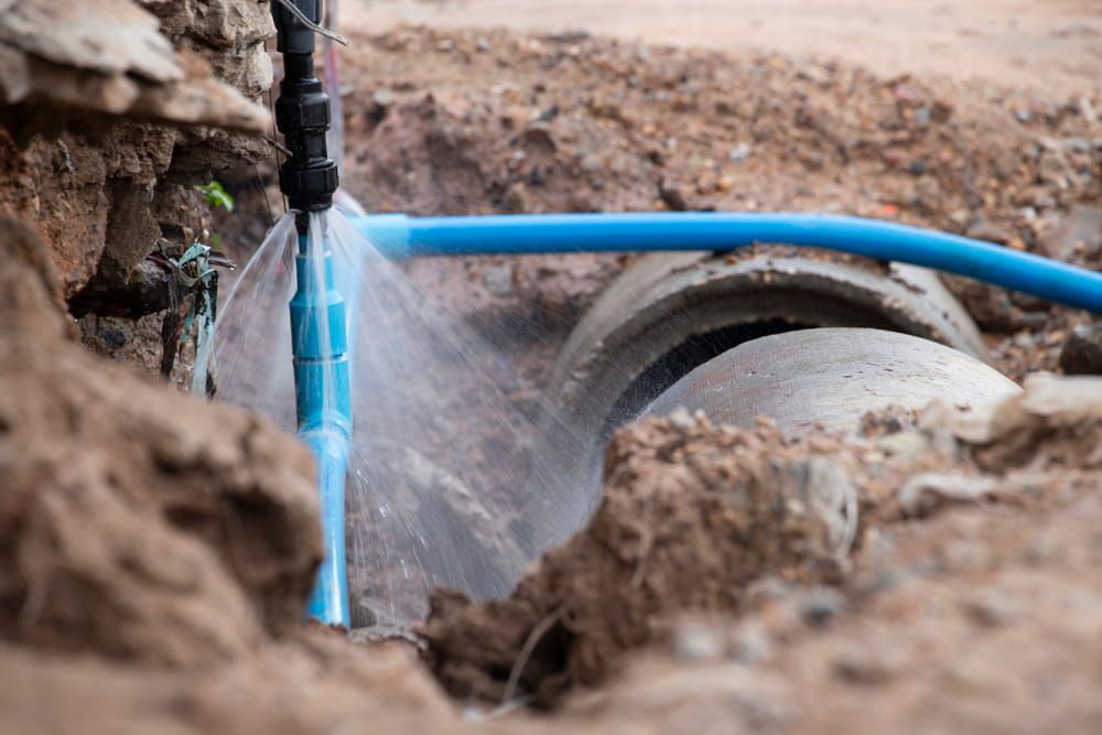 A Water Pipe Is Leaking Water in The Dirt — Blair Merlehan Plumbing in Wagga Wagga, NSW