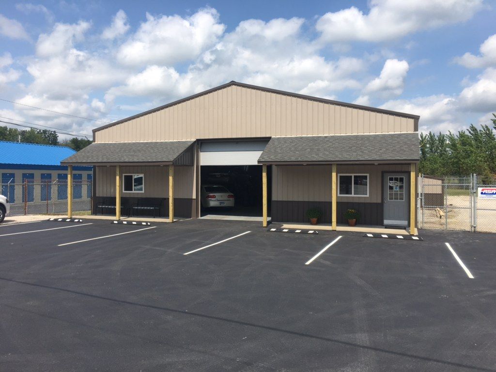 Empty parking lot in front of a beige commercial building under a partly cloudy sky