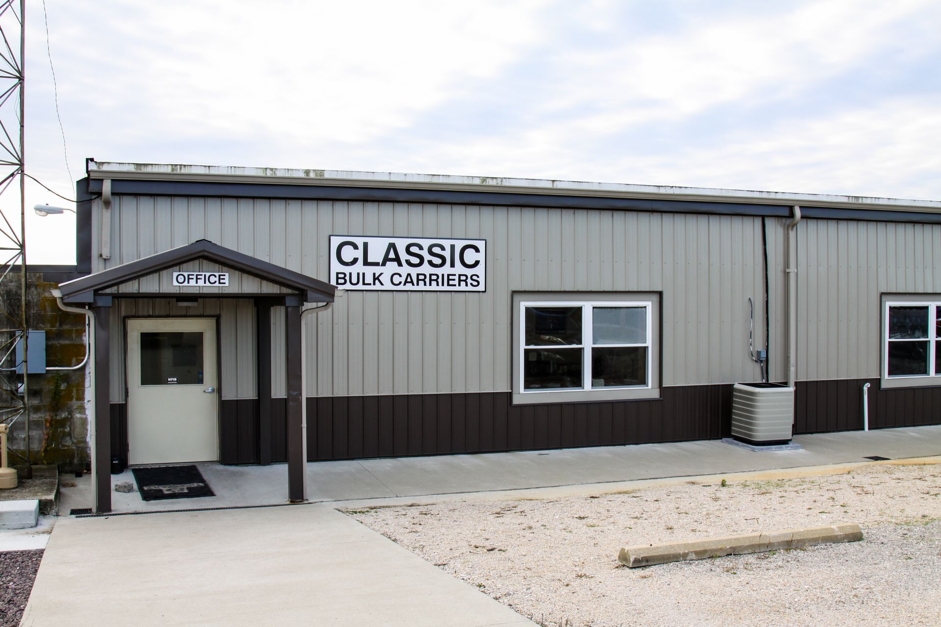 Exterior of Classic Truck Parts building with a covered entrance and gravel parking area