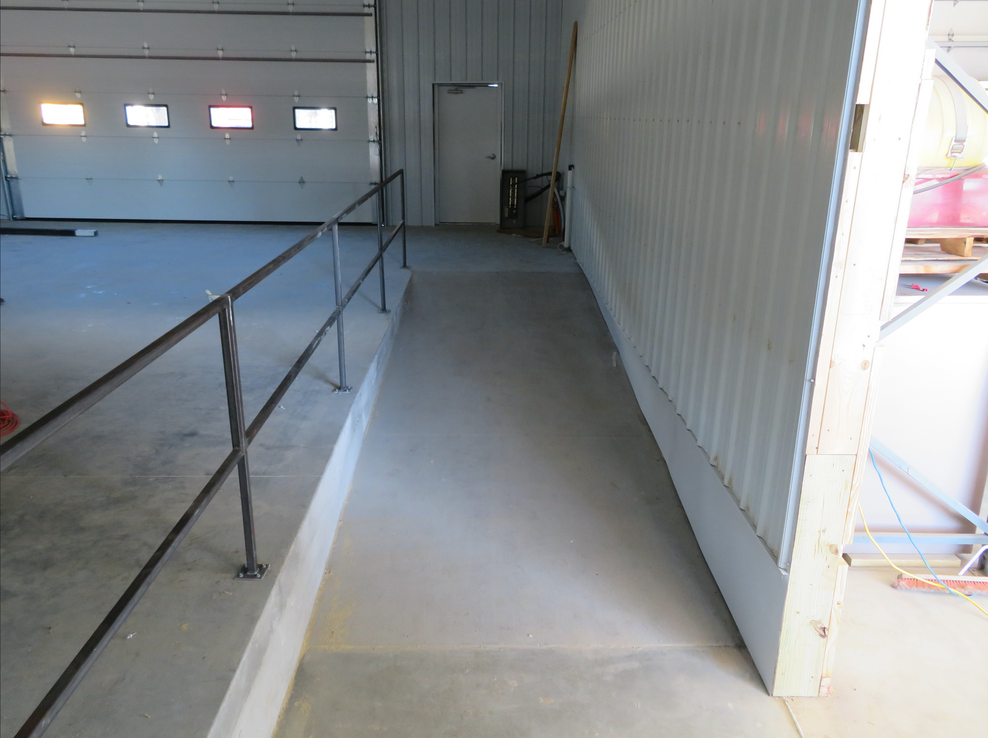 Concrete ramp with metal handrails inside a warehouse or loading bay