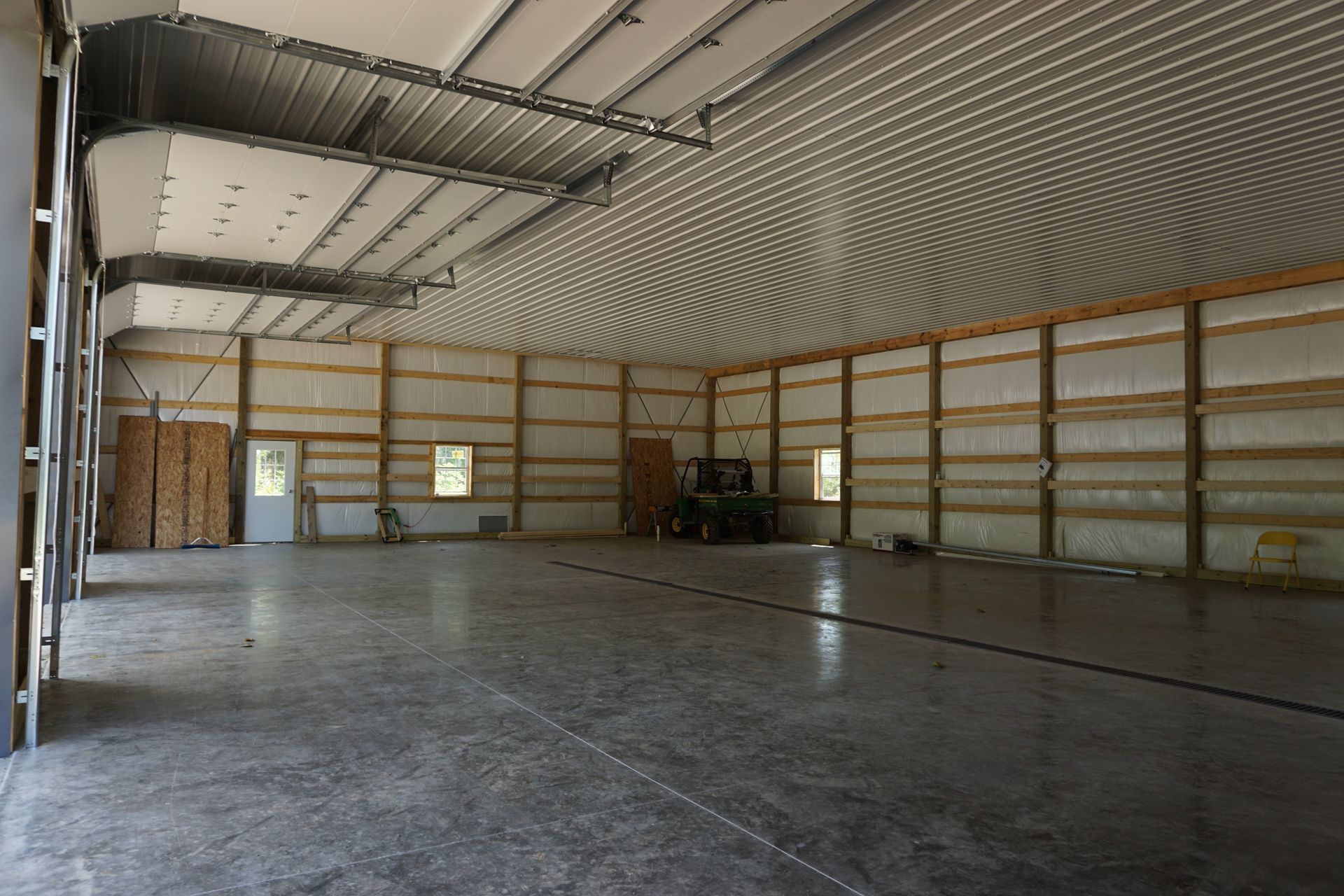 Empty metal-walled warehouse with a concrete floor and large open interior.