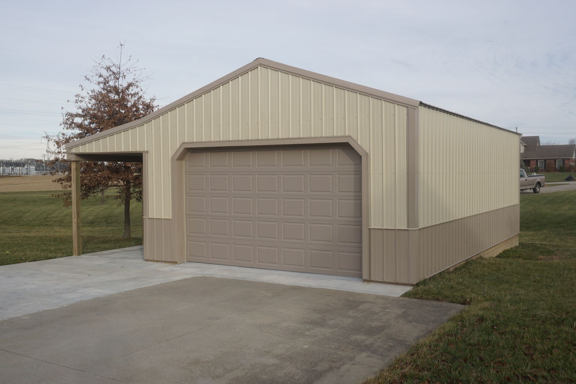 Tan beige detached garage with a single door and concrete driveway in a grassy yard