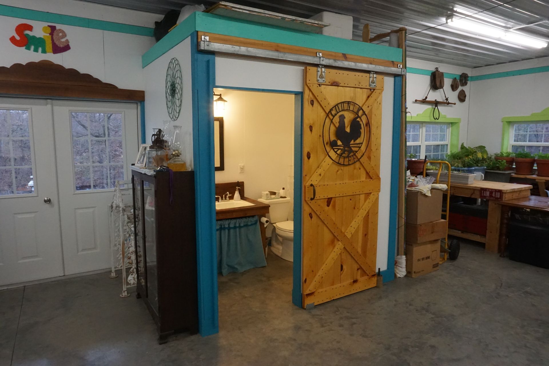 Indoor workspace with open yellow door, white double doors, desks, and bright teal walls