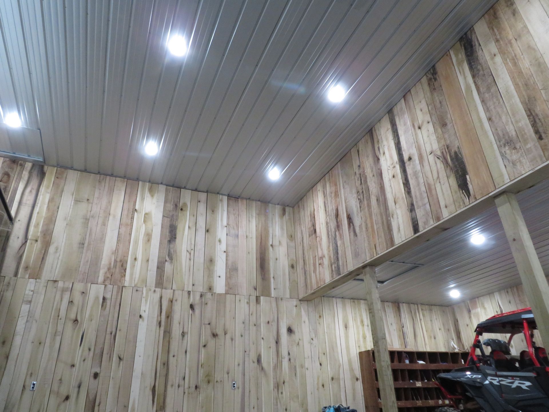 Wood-paneled interior with recessed ceiling lights and shelving in the corner