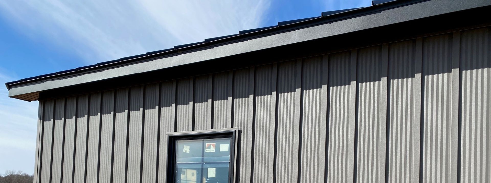 Gray metal building with a blue door under a clear sky