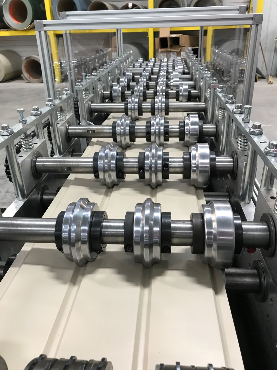 Rows of metal rollers on a conveyor line in an industrial factory setting