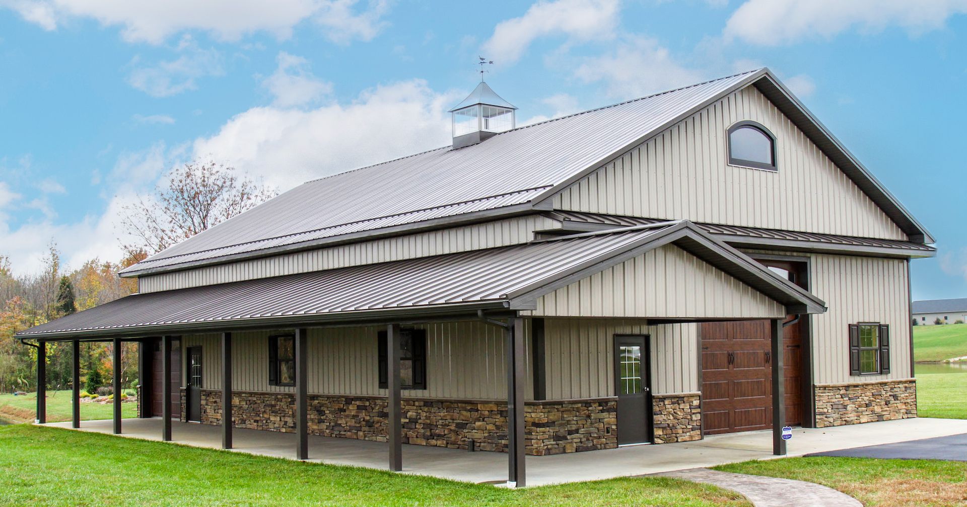 Rural barn-style building with metal roof and covered porch on a grassy lot