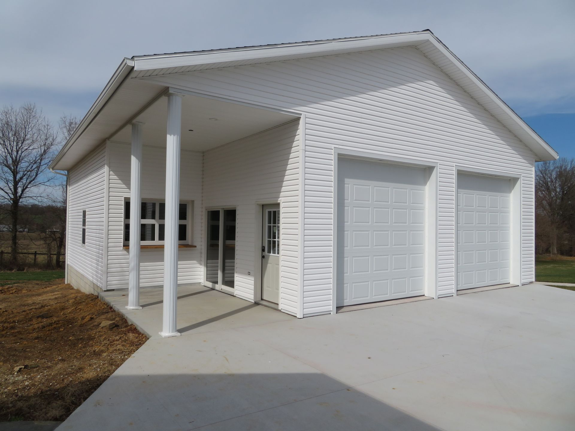 White two-car garage with covered porch and concrete driveway
