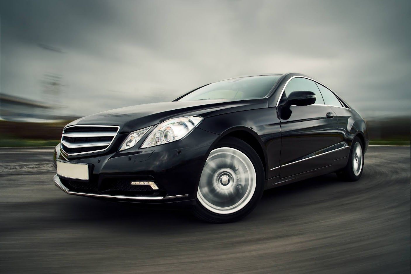 Black luxury sedan speeding on a blurred road