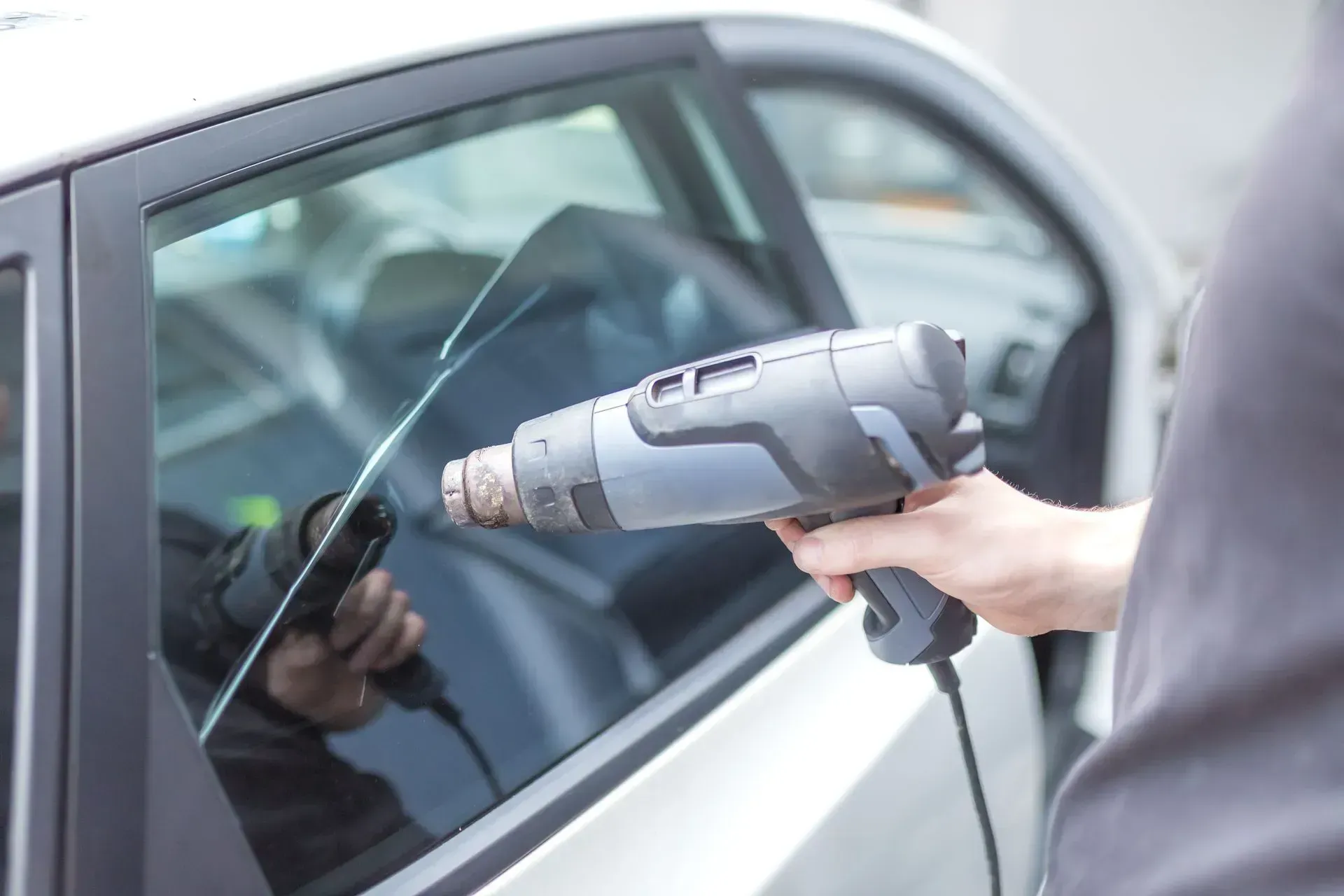 Person Using Heat Gun To Apply Tint Film To a Car