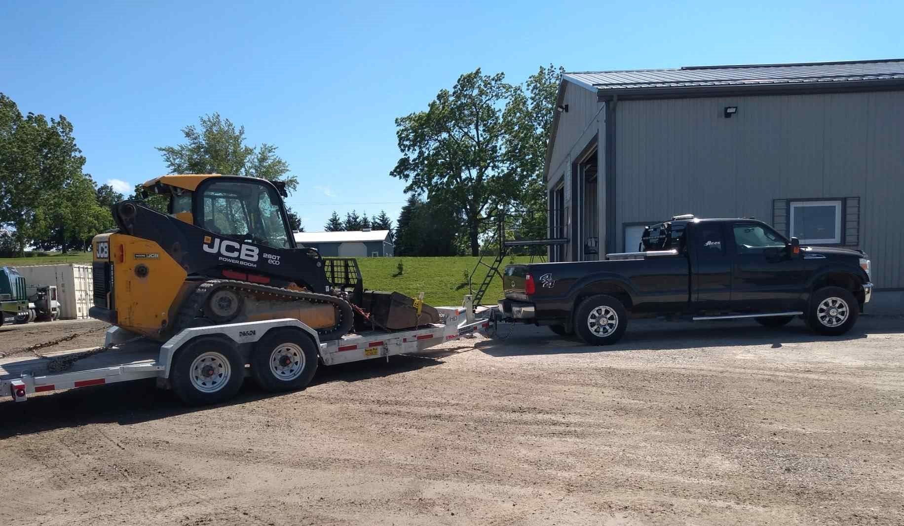 A truck is towing a bulldozer on a trailer.