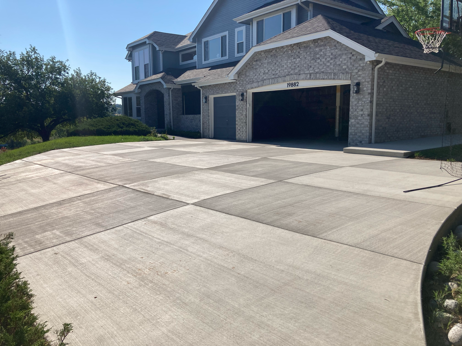 Finished concrete driveway with scored panels sloping up to an attached garage