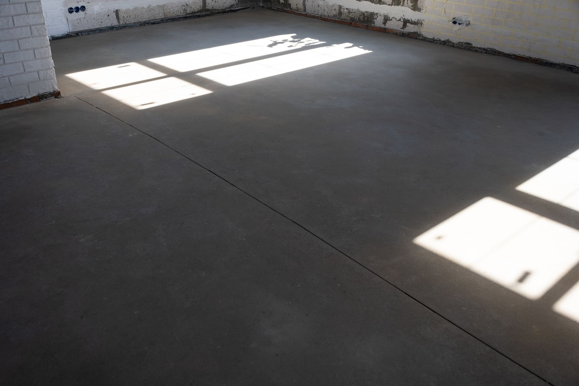 A room with a concrete floor and a window.