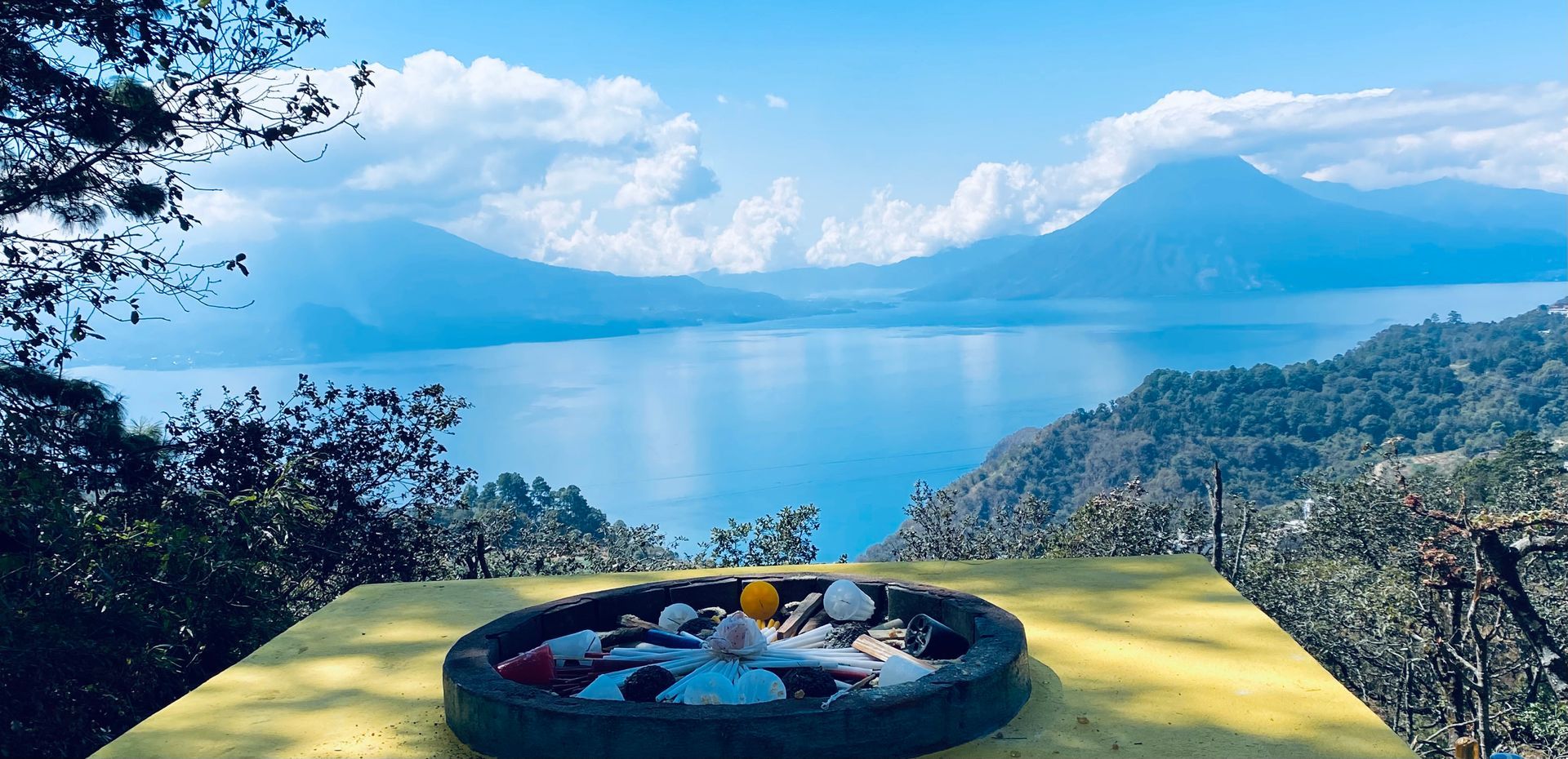 Ein gelber Tisch mit Blick auf einen See und Berge im Hintergrund.