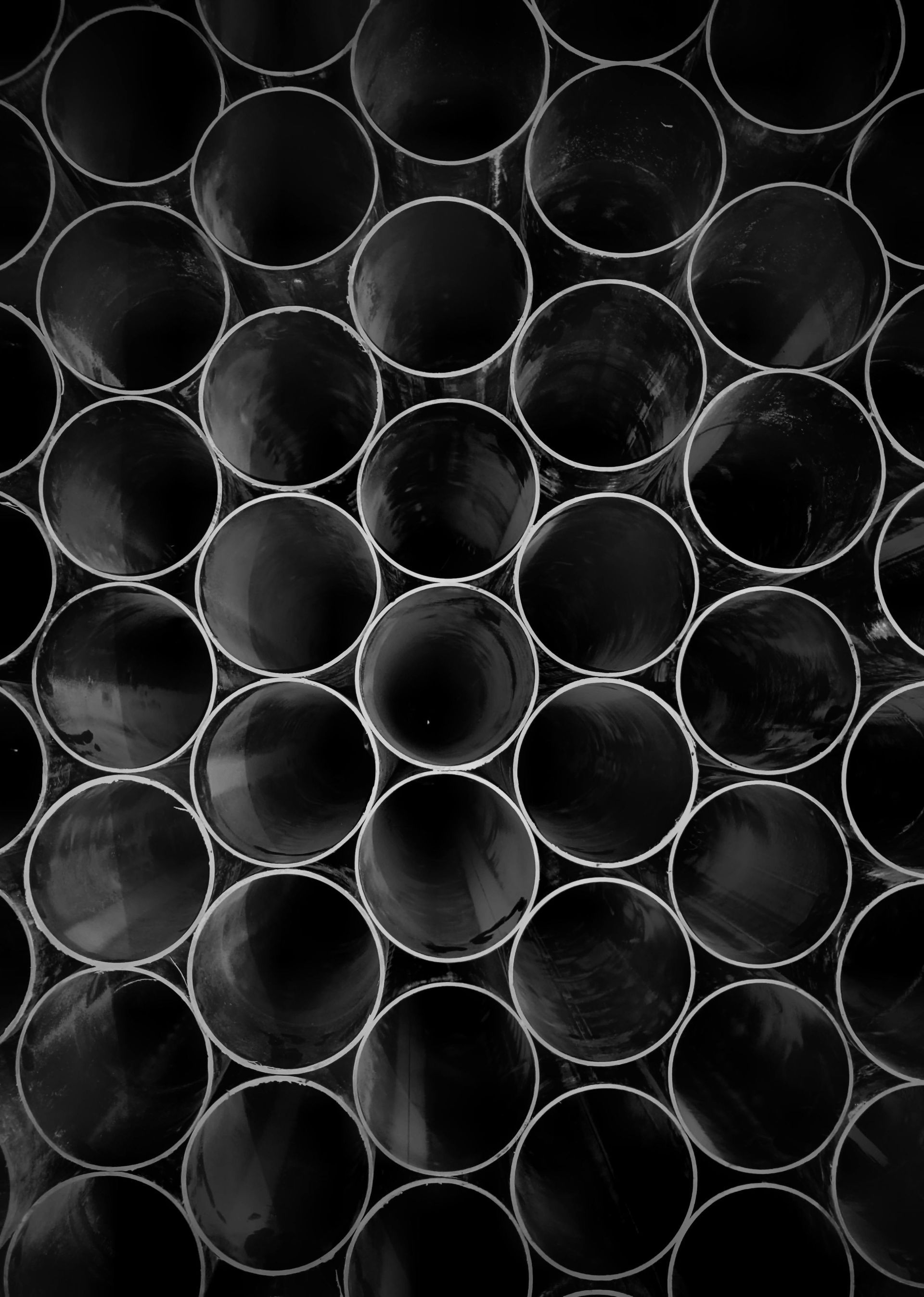 Stacked black circular tubes viewed from above, forming a tight repeating pattern.