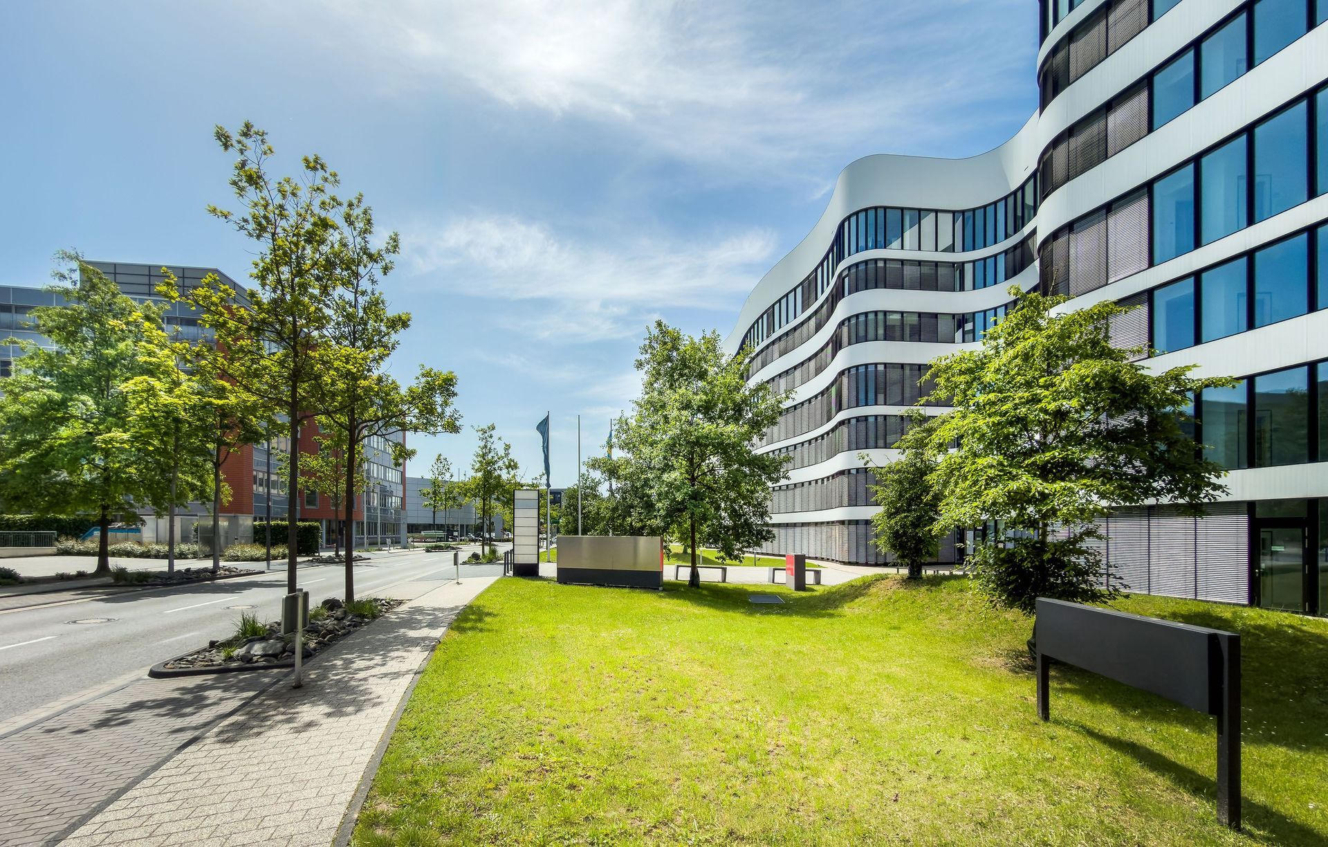 Office buildings across the street from multi-use development and green space in front. 