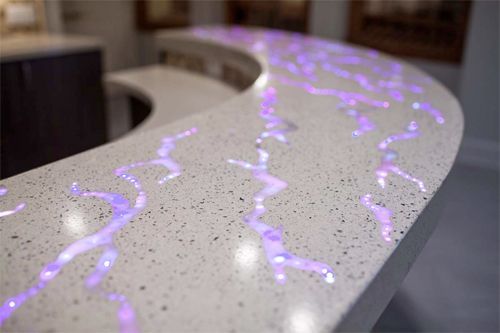 Curved white countertop with glowing purple light patterns on a speckled surface