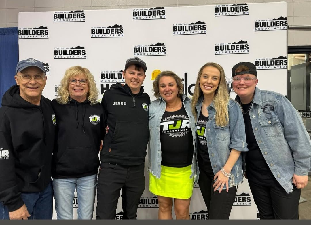 Six people posing in front of a Builders-branded backdrop, smiling at an event.