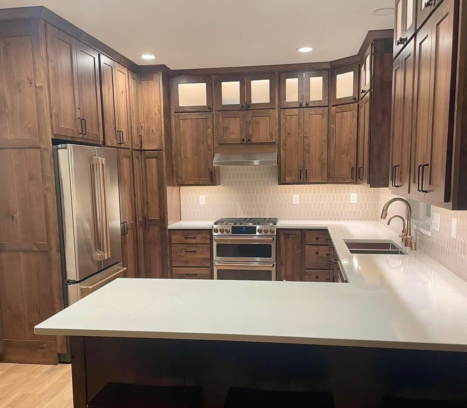 Modern kitchen with dark wood cabinets, stainless appliances, and a light island countertop