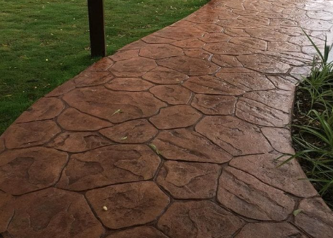 Stamped concrete walkway beside grass and plants