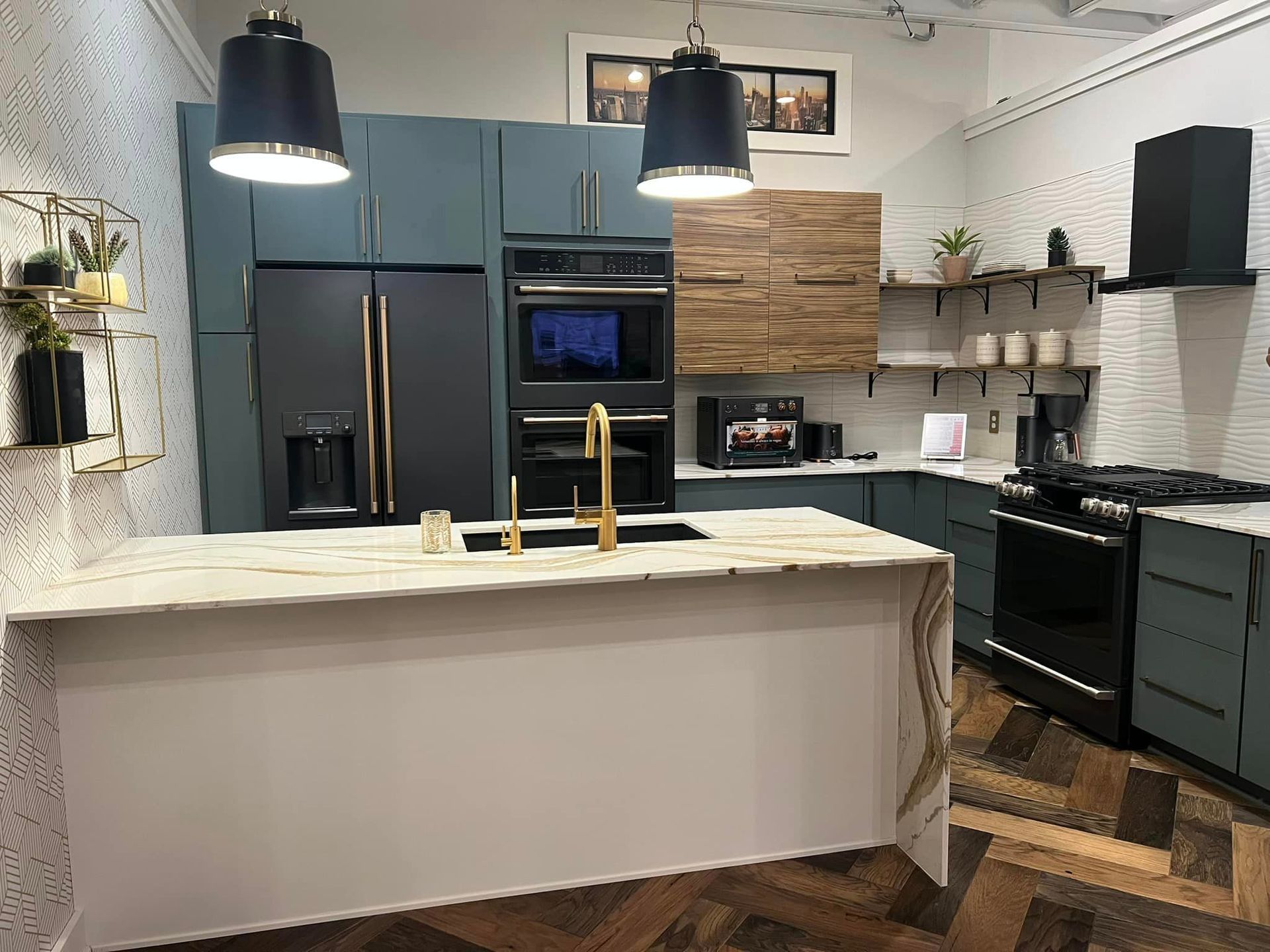 Modern kitchen with blue cabinets, black appliances, and a white island under pendant lights