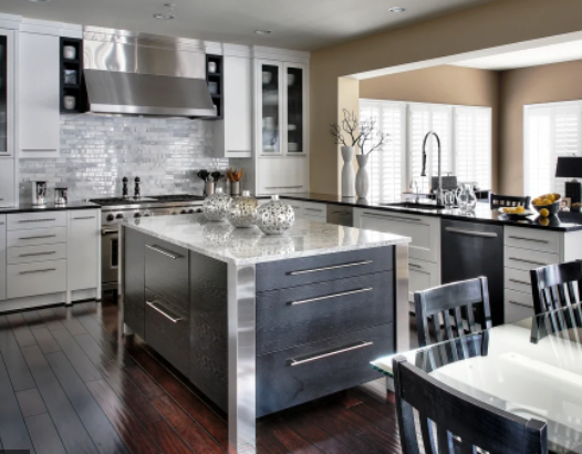 Modern kitchen with stainless-steel appliances, dark wood floors, and a large island set for dining.