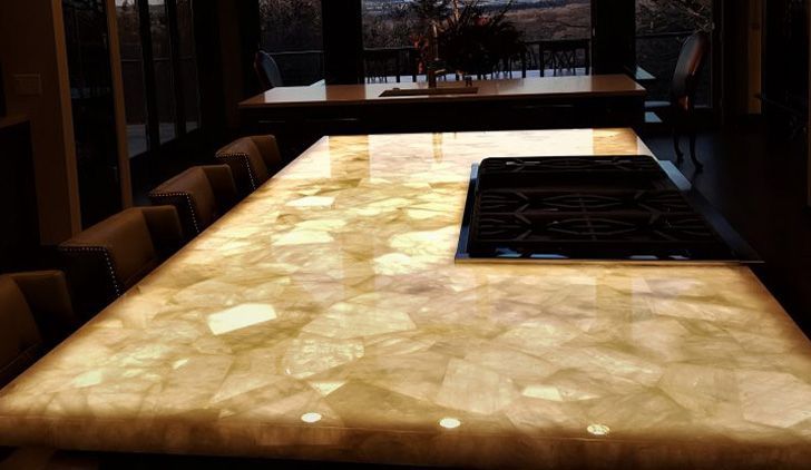 Glowing stone table in a dim restaurant interior with chairs and windows in the background