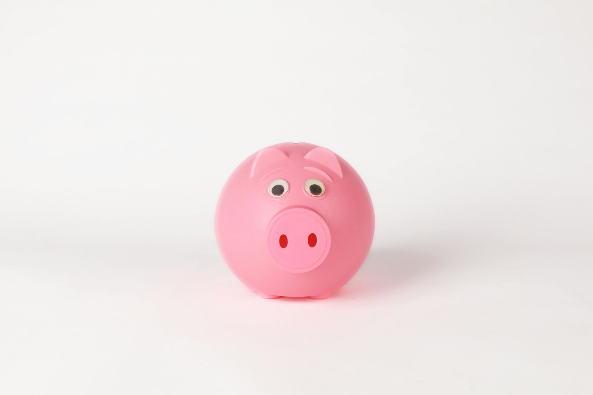 Pink piggy bank with a smiling face on a white background