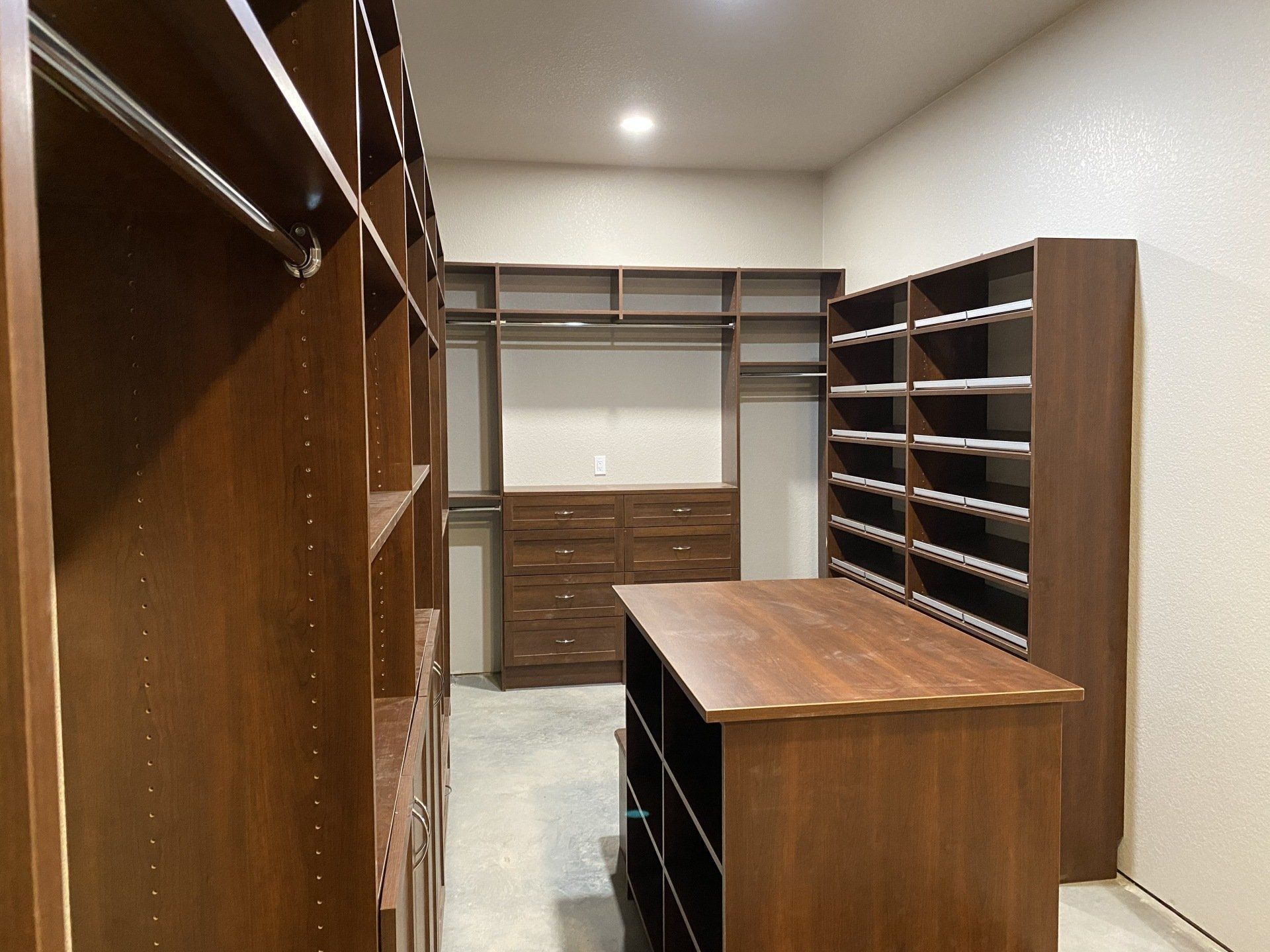 A walk in closet with lots of shelves and drawers