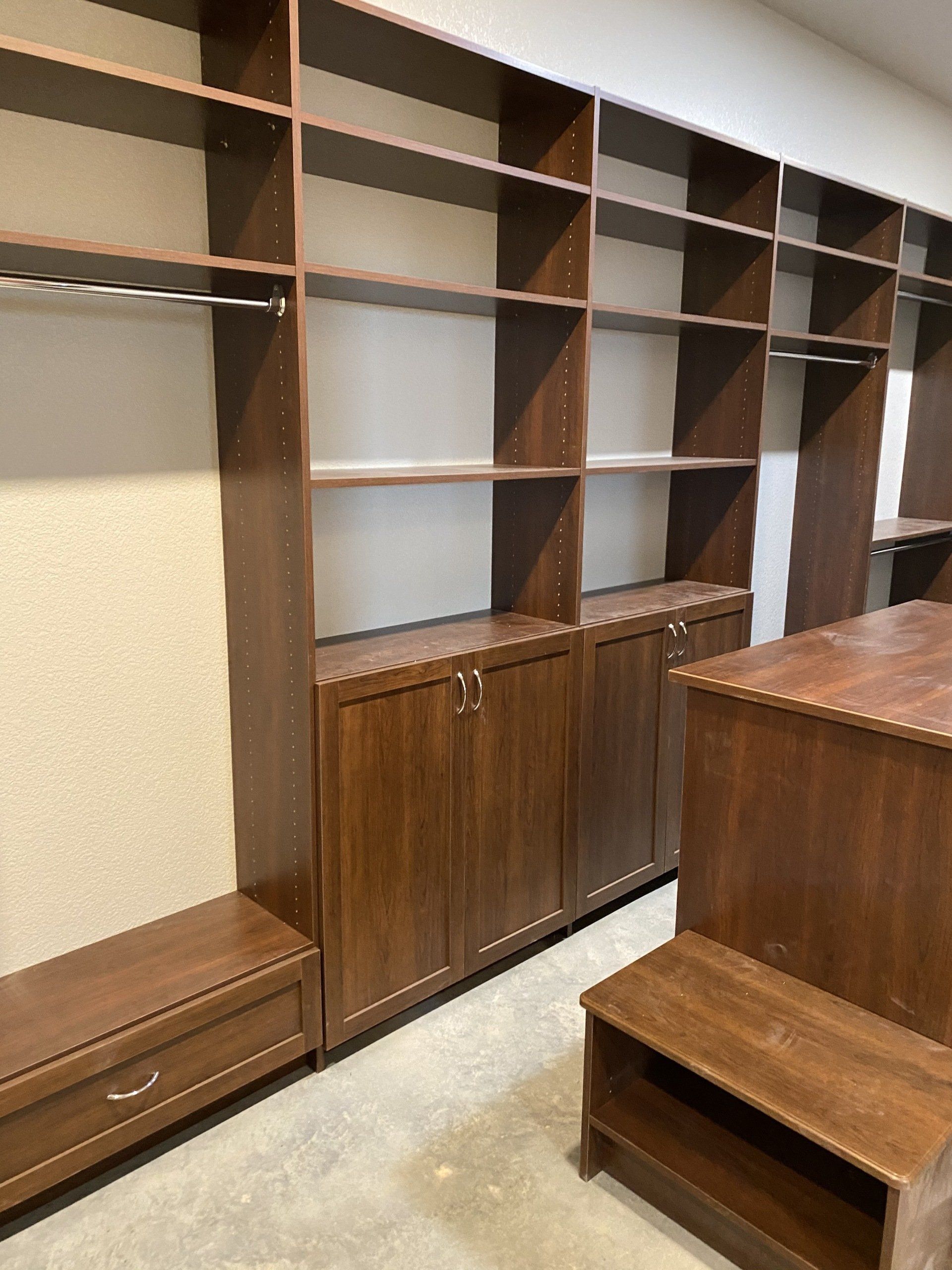 A walk in closet with lots of shelves and cabinets