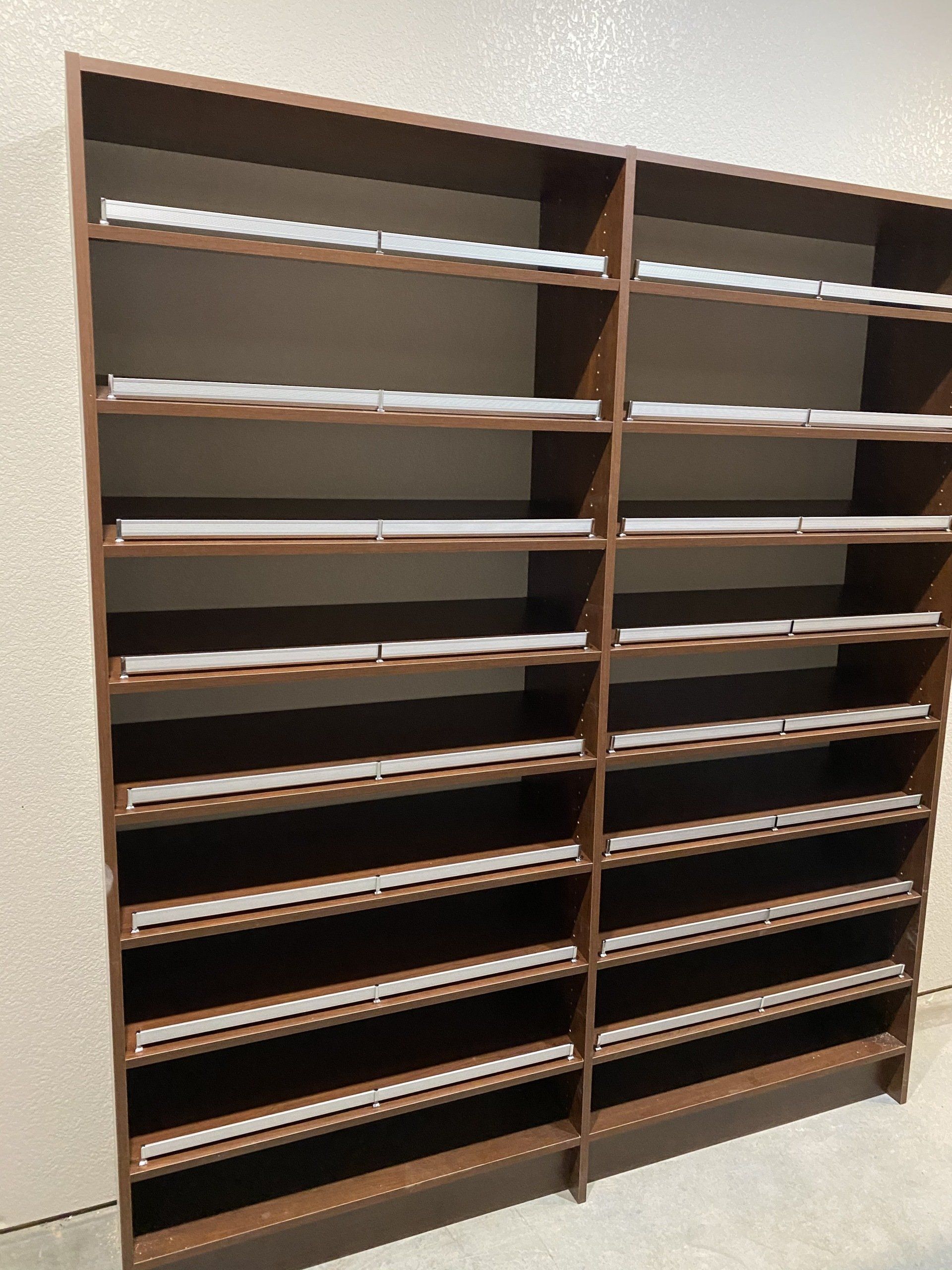 A row of wooden shelves filled with papers on a wall.