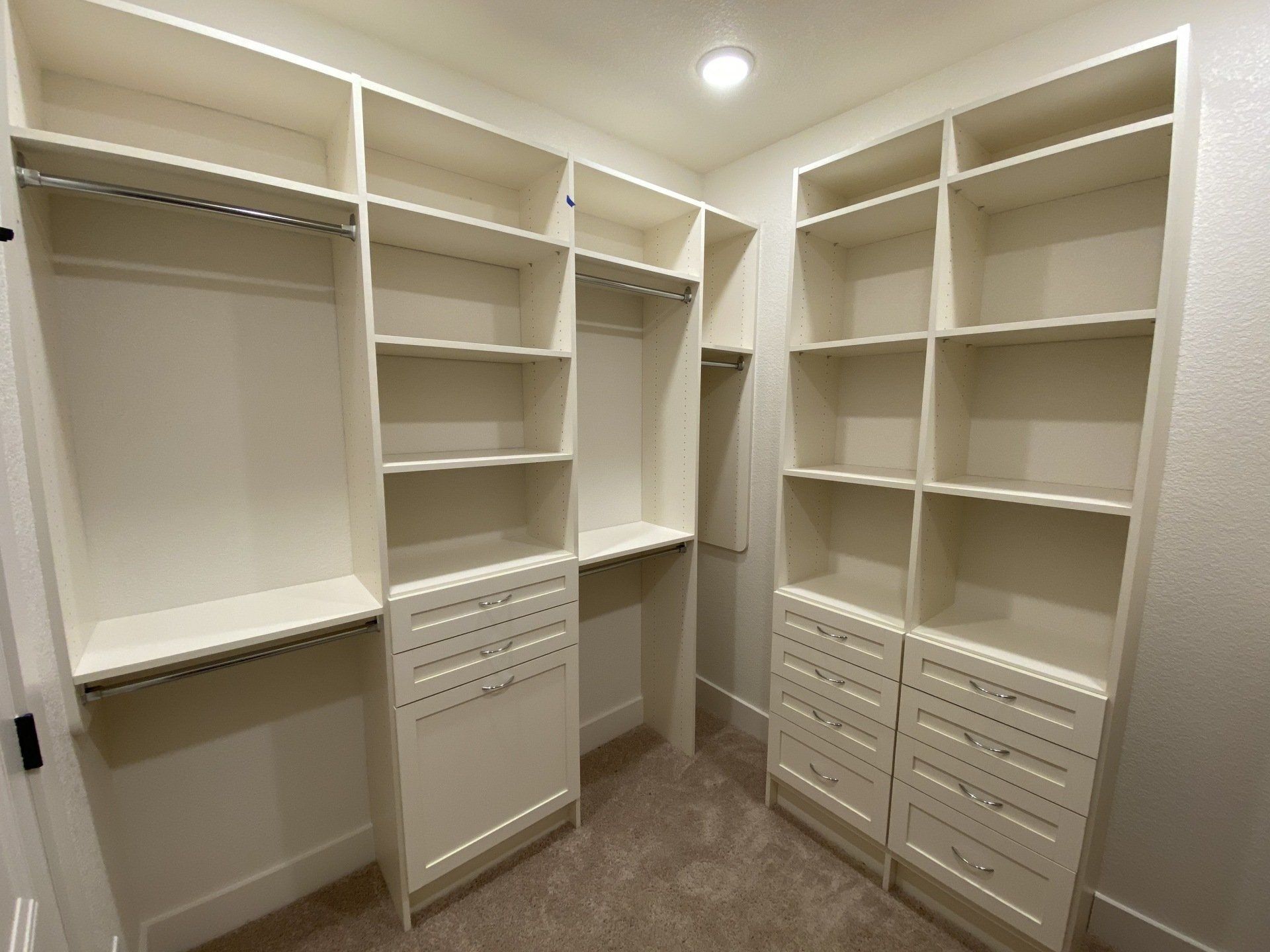 A walk in closet with lots of shelves and drawers.