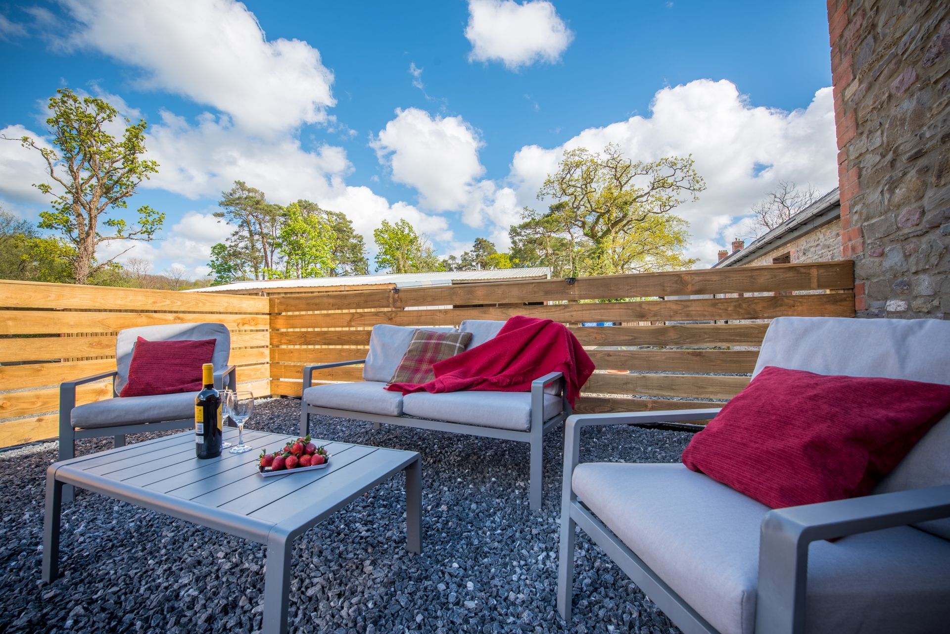 Outdoor terrace at The Coach House with rattan furniture and countryside views.