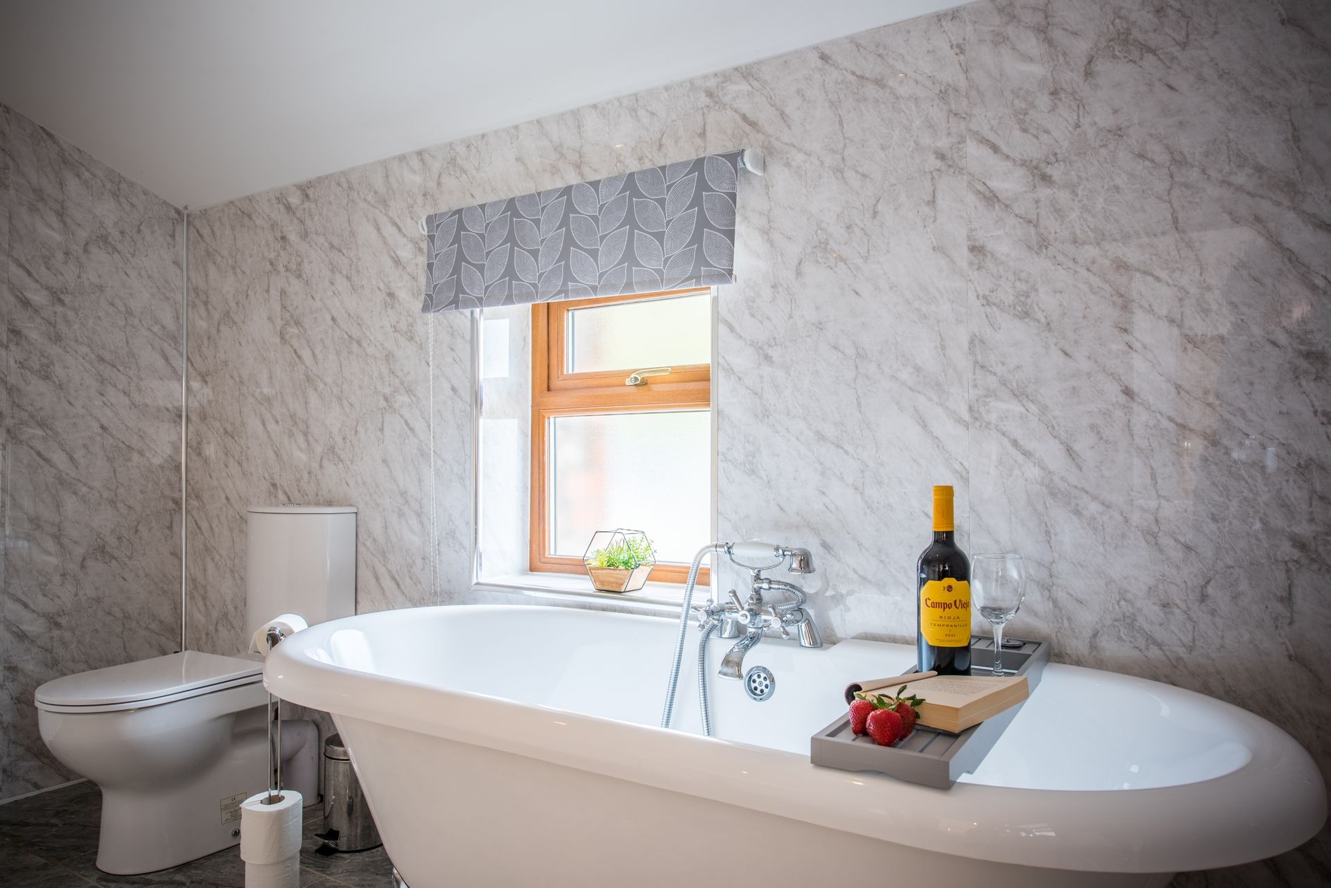Freestanding bath with champagne and towel at The Cowshed, Green Grove Barns.
