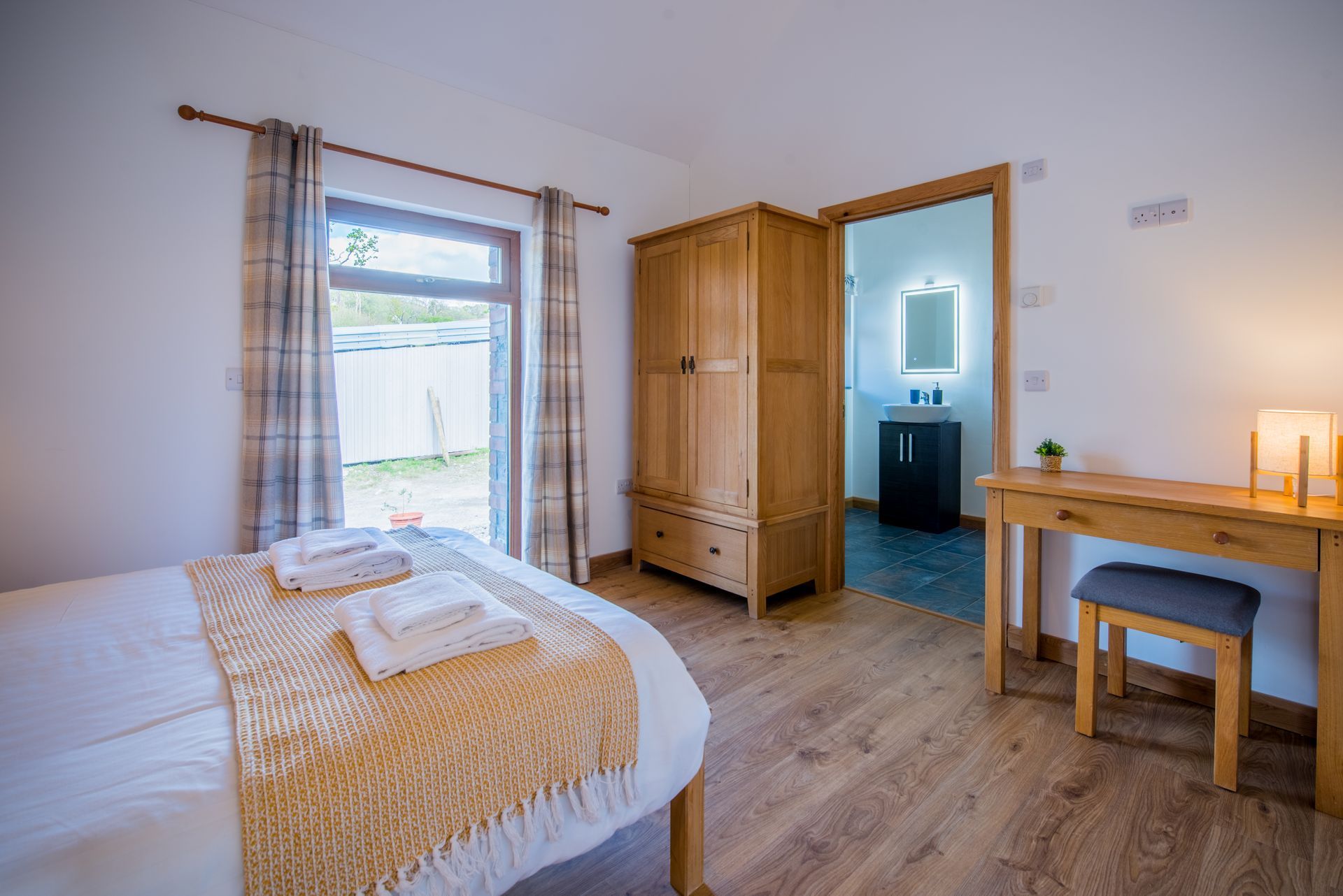 Spacious bedroom with dressing table and en-suite at The Coach House, Green Grove Barns.