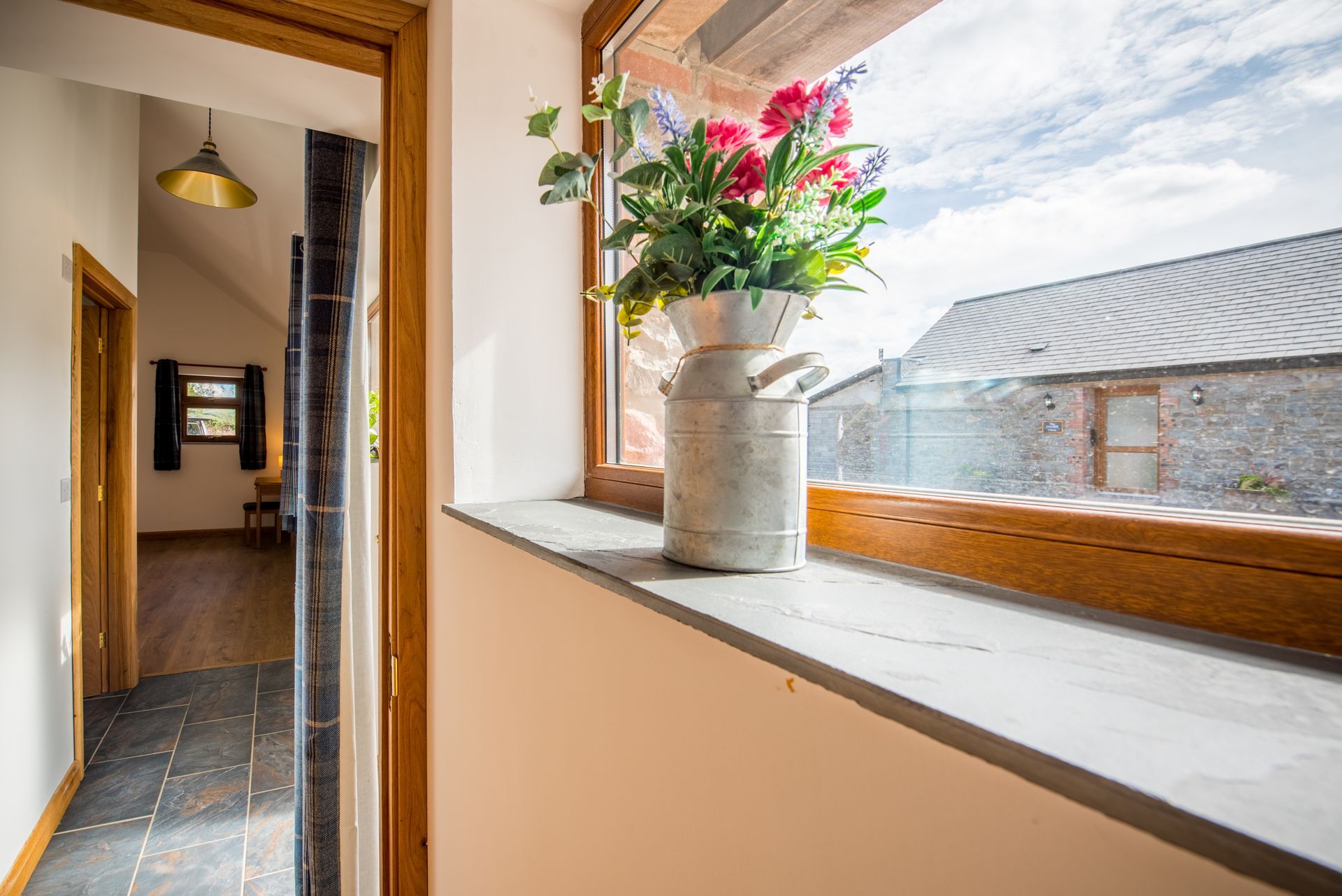 Flower arrangement on windowsill at The Coach House overlooking courtyard at Green Grove Barns.