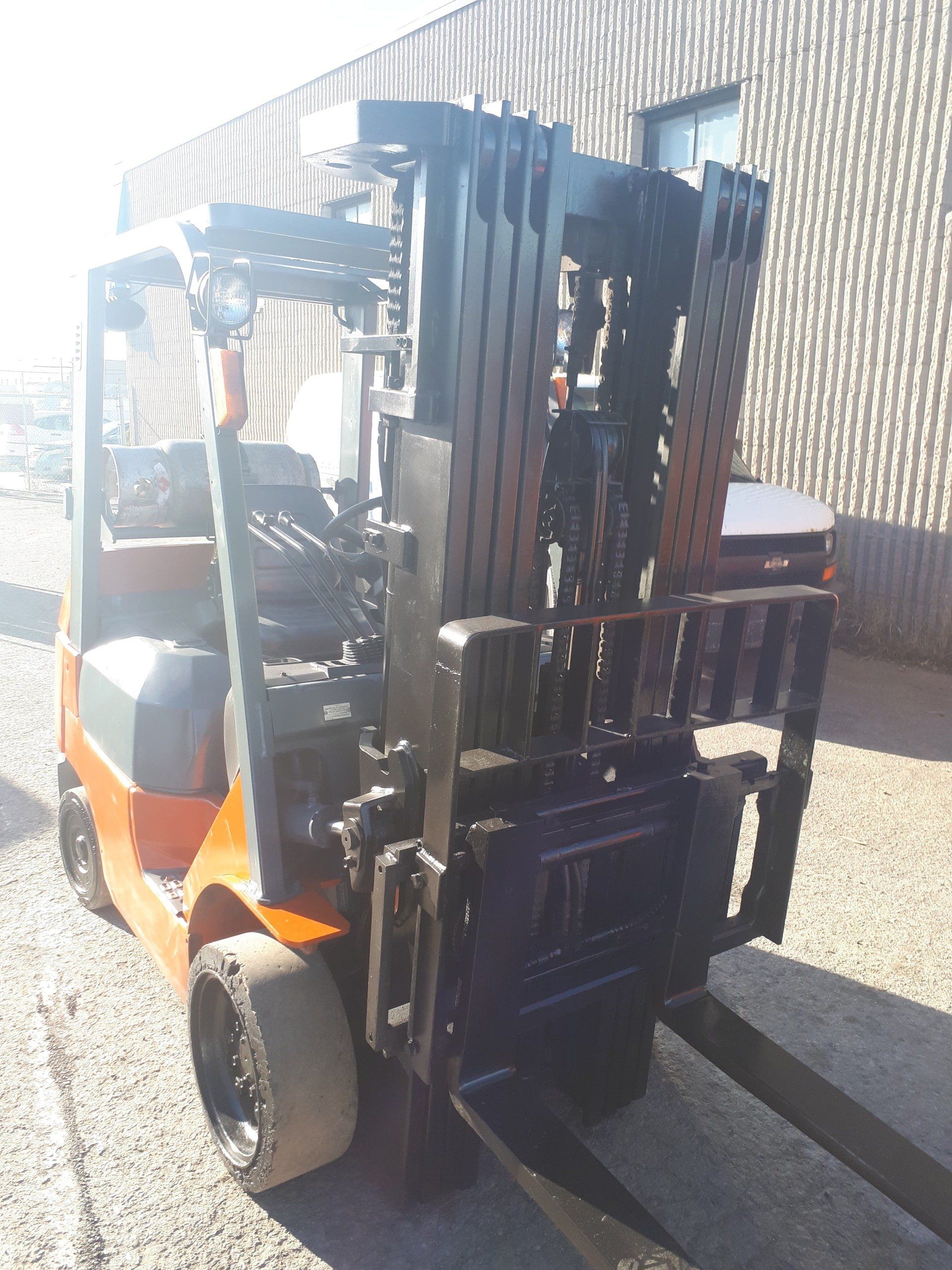 A forklift is parked in front of a building