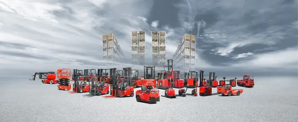 Collection de chariots élévateurs rouges sur fond gris avec ciel nuageux.