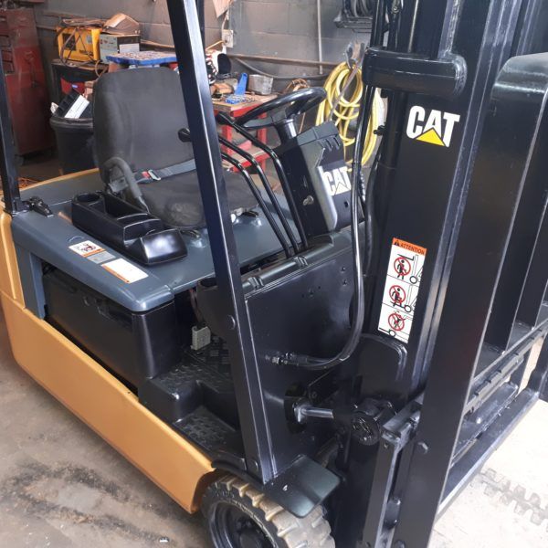 Intérieur d'un chariot élévateur avec tableau de bord, commandes et outils de maintenance visibles.